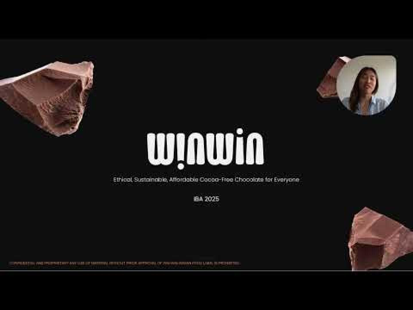 Eine Präsentationsfolie mit dem Titel „Win-win“ und dem Slogan „Ethische, nachhaltige und erschwingliche kakaofreie Schokolade für alle“. Zu sehen sind Schokoladenstücke, ein kurzes Video einer sprechenden Frau und der Text „IBA 2025“ auf schwarzem Hintergrund.