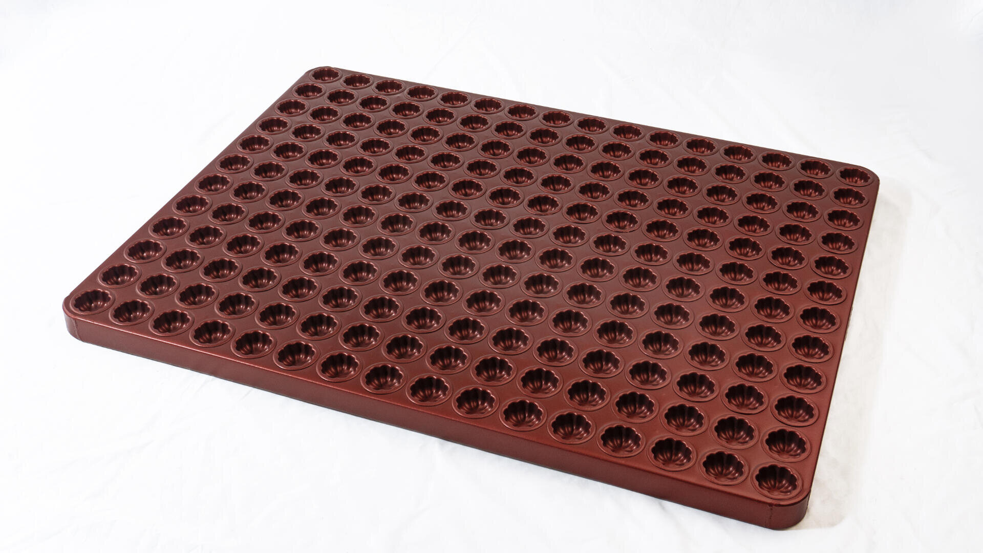 A rectangular, dark red mat with rows of evenly spaced, circular flower-like indentations on its surface, placed on a white background.