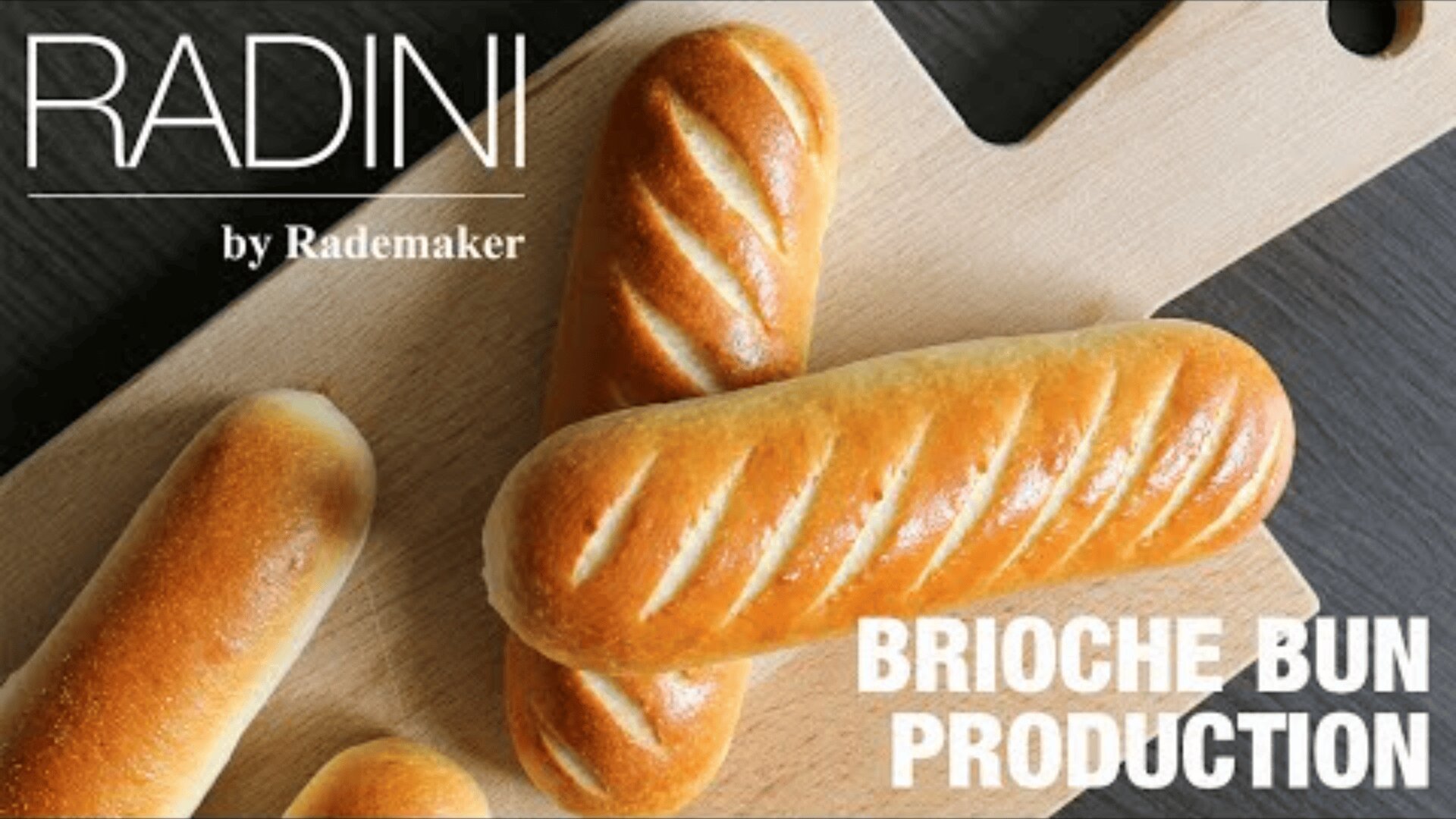 Three golden brioche buns with diagonal incisions lie on a wooden cutting board. The text RADINI by Rademaker and BRIOCHE BUN PRODUCTION is superimposed over the image.