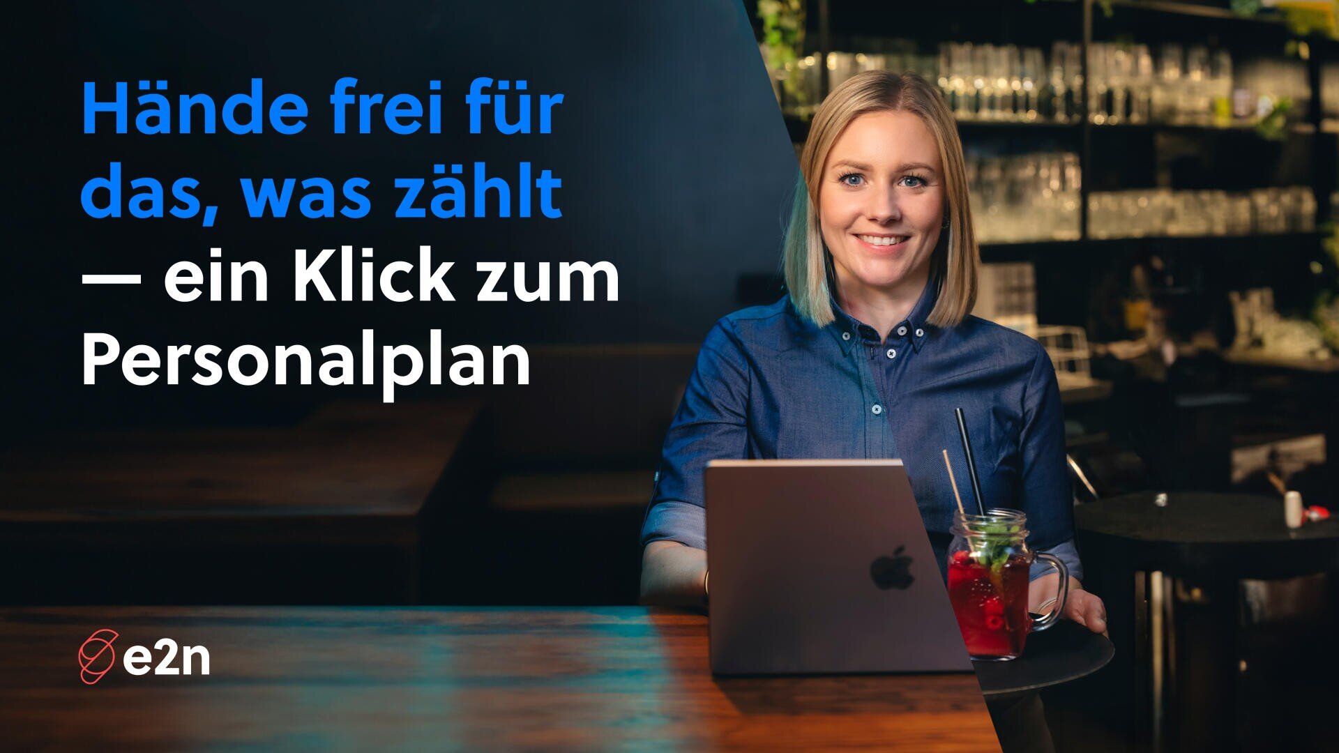 Eine lächelnde Frau sitzt an einer Bar mit einem Laptop und einem roten Getränk. Blauer und weißer deutscher Text lautet: Hände frei für das, was zählt - ein Klick zum Personalplan. Das e2n-Logo erscheint in der unteren linken Ecke.