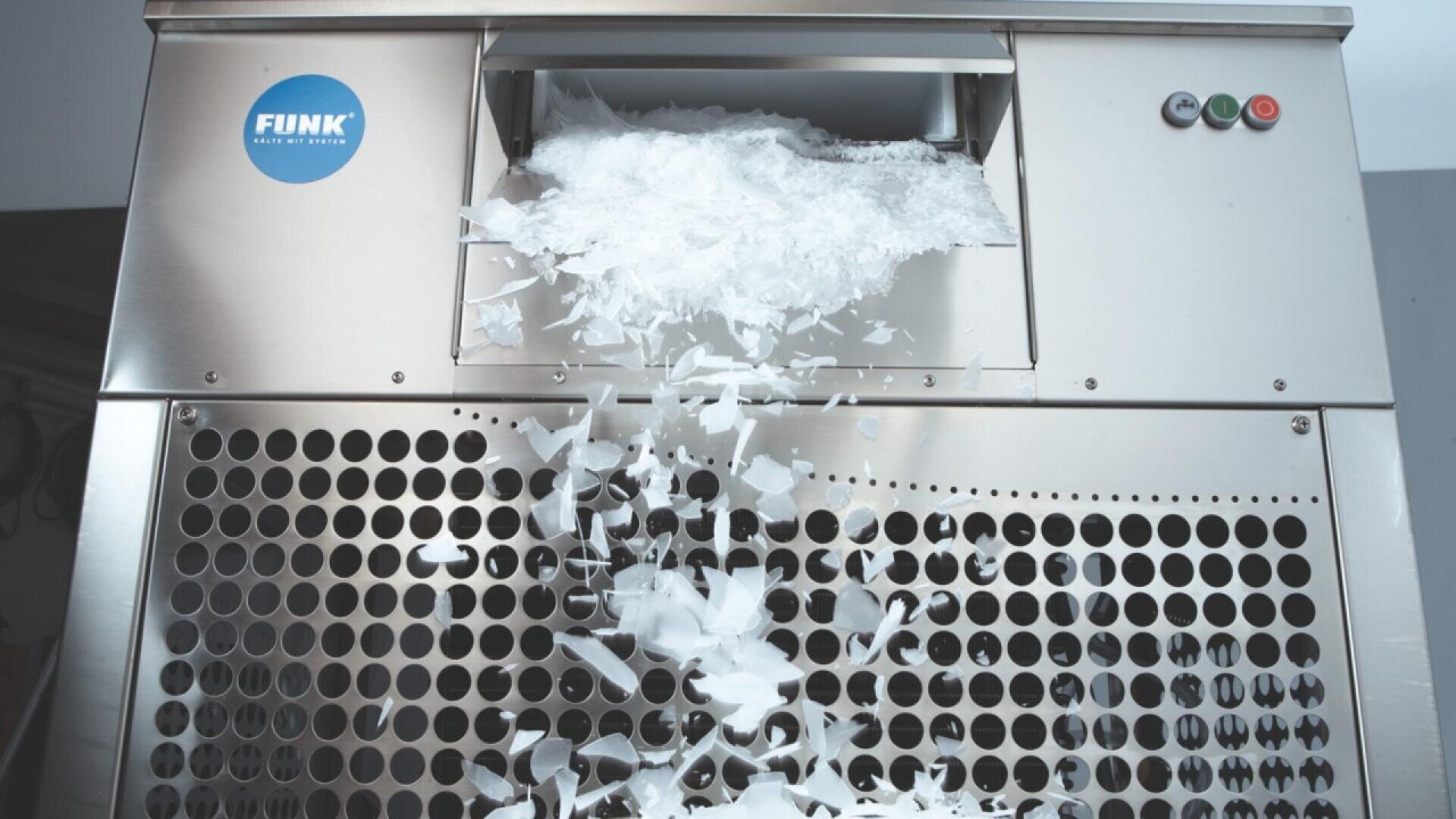 A stainless steel ice machine dispensing thin, flat ice flakes through a grated opening, with ice cascading downward. Three buttons and a blue FUNK logo are visible on the front.