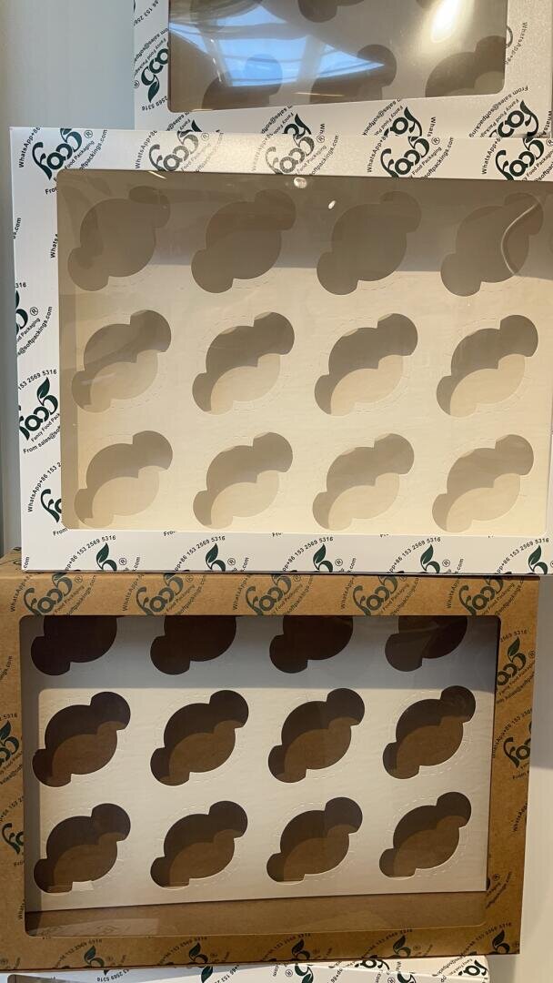 Three stacked cardboard boxes with clear plastic windows, each decorated with a repeating pattern of cloud-shaped cutouts on the inner liners. The boxes have a white and brown color scheme.
