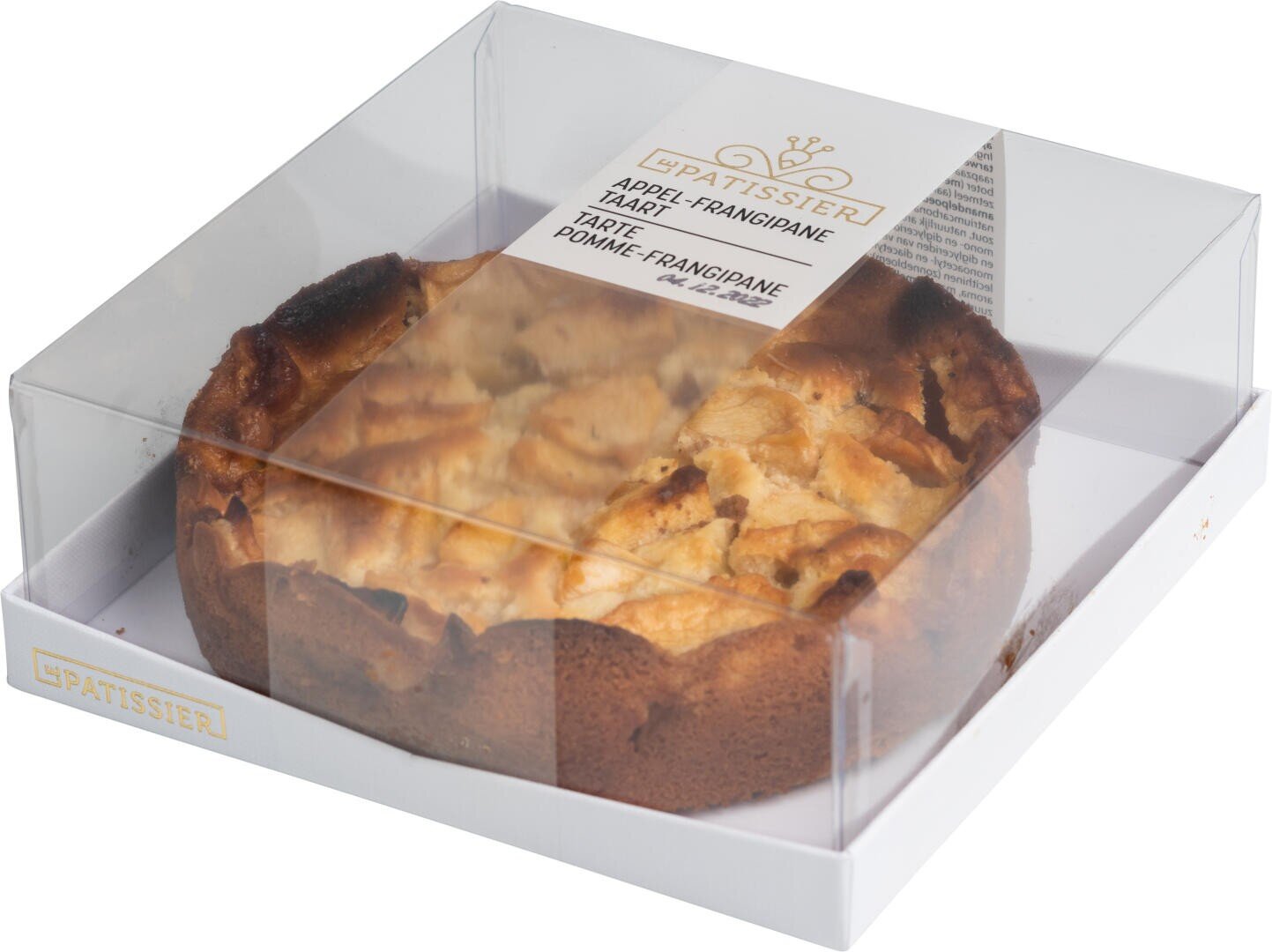 Round apple frangipane tart in a white cardboard box with a clear plastic lid, showing the golden-brown baked surface and apple slices. The label on top reads PATISSIER Apple-Frangipane Tart.