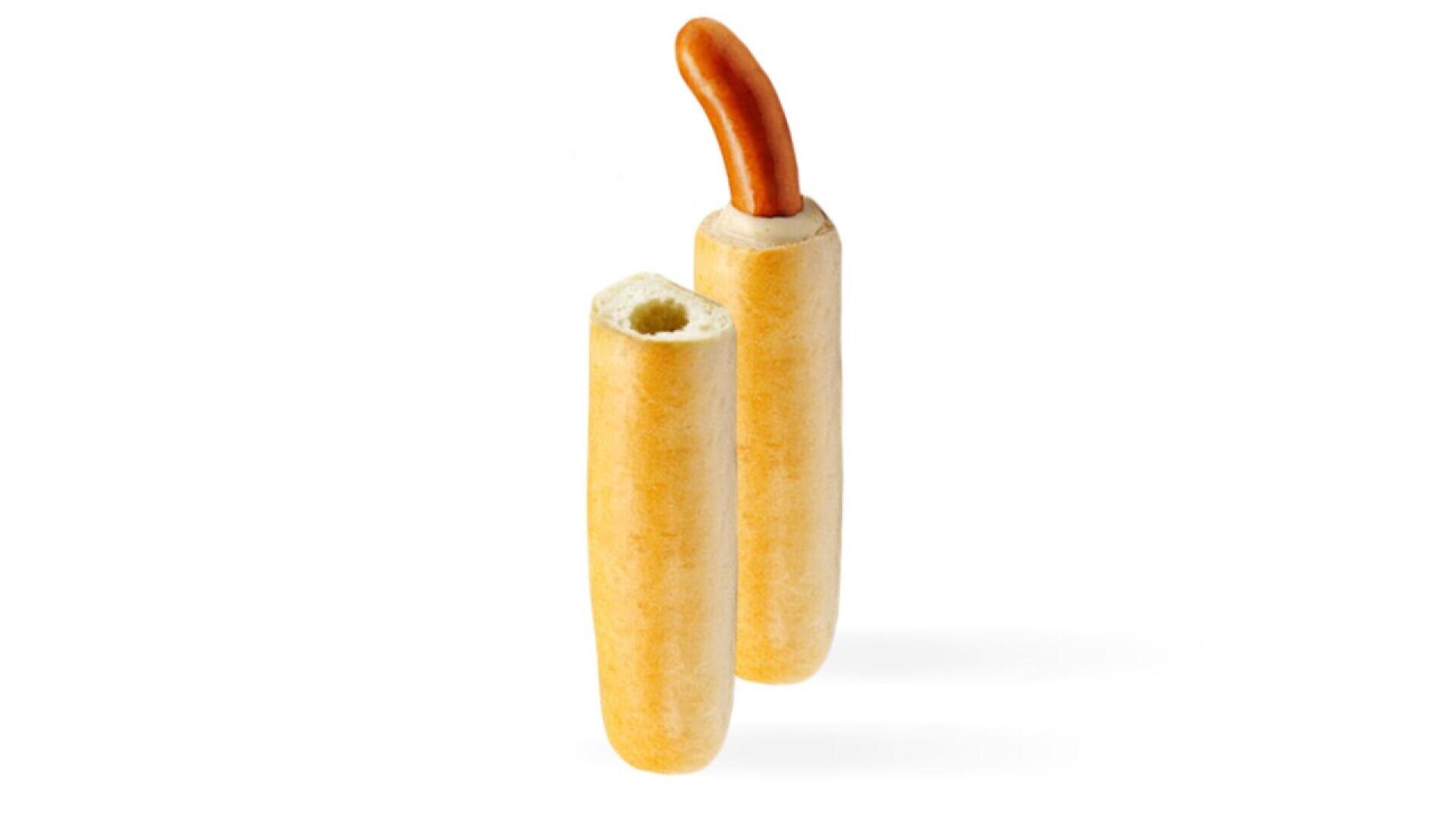 Two baguette-style pieces of bread with hollow centers, one holding a hot dog sausage partially sticking out, against a plain white background.