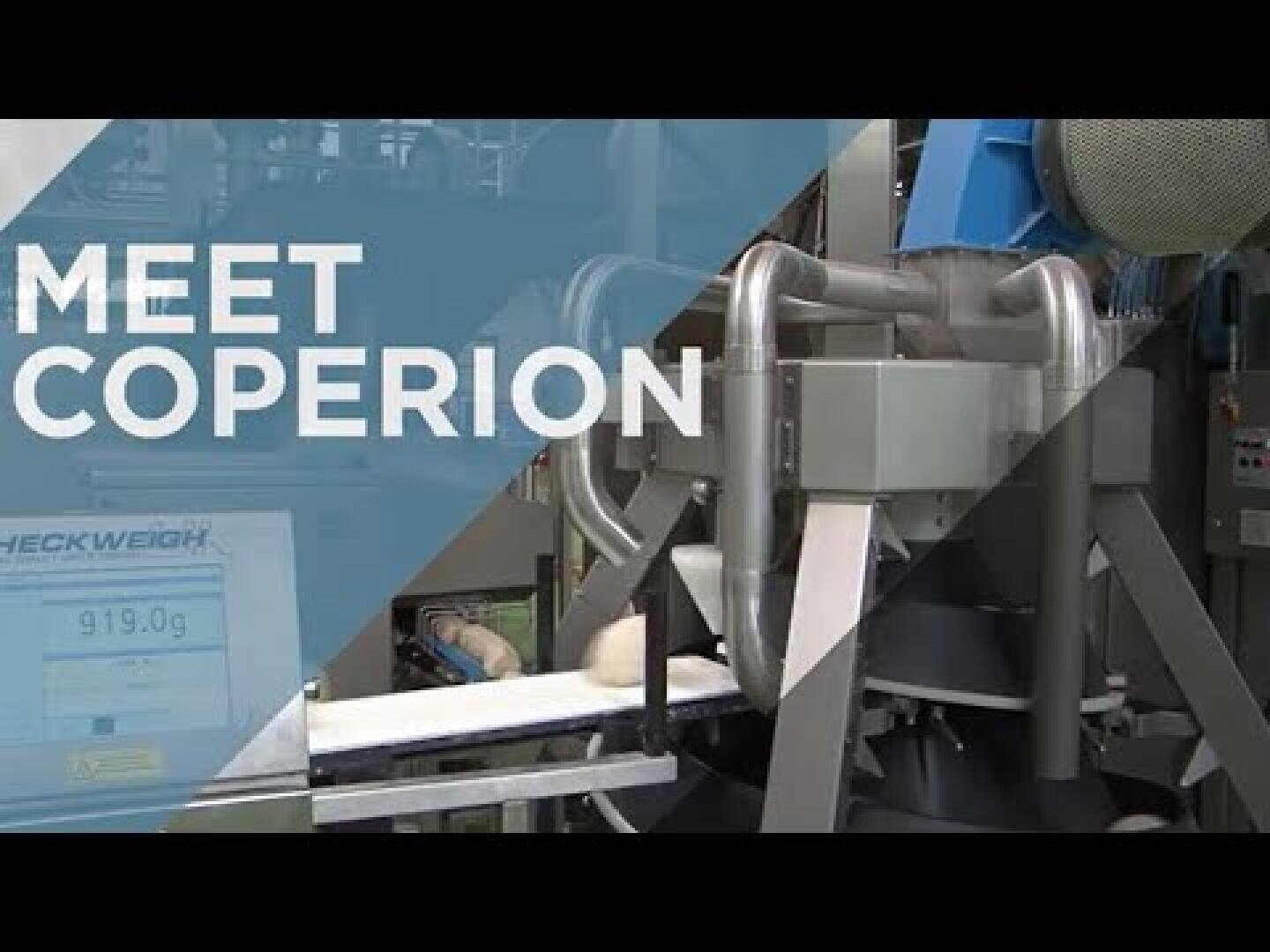 Industrial machinery with metal pipes and a conveyor belt in a factory. The text MEET COPERION is displayed on the left side of the image. A digital display shows 919.0 g.