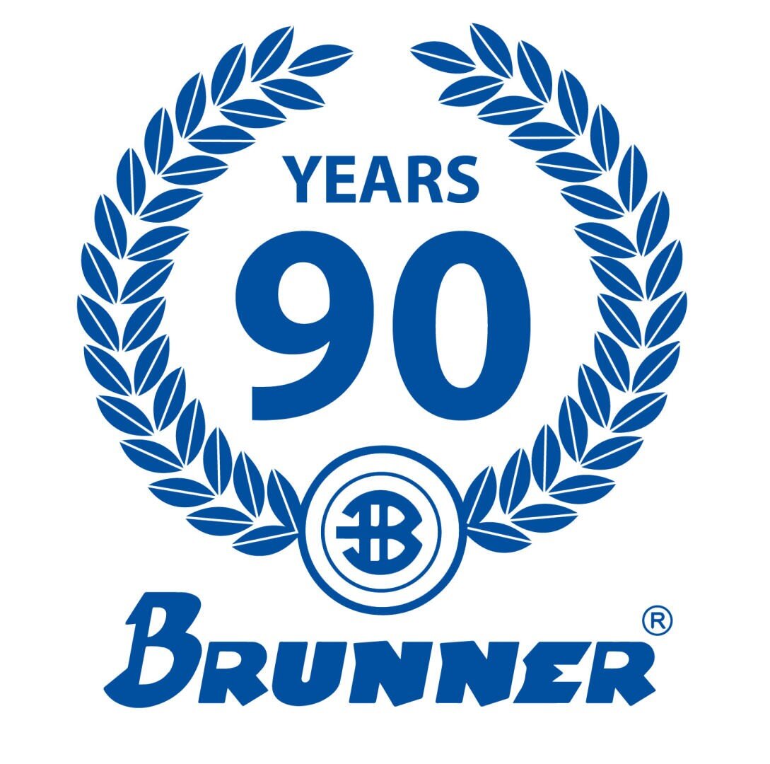 Blue laurel wreath encircling the text 90 YEARS with a circular logo below. The name Brunner is written in bold below the wreath. The design marks a 90th anniversary celebration.