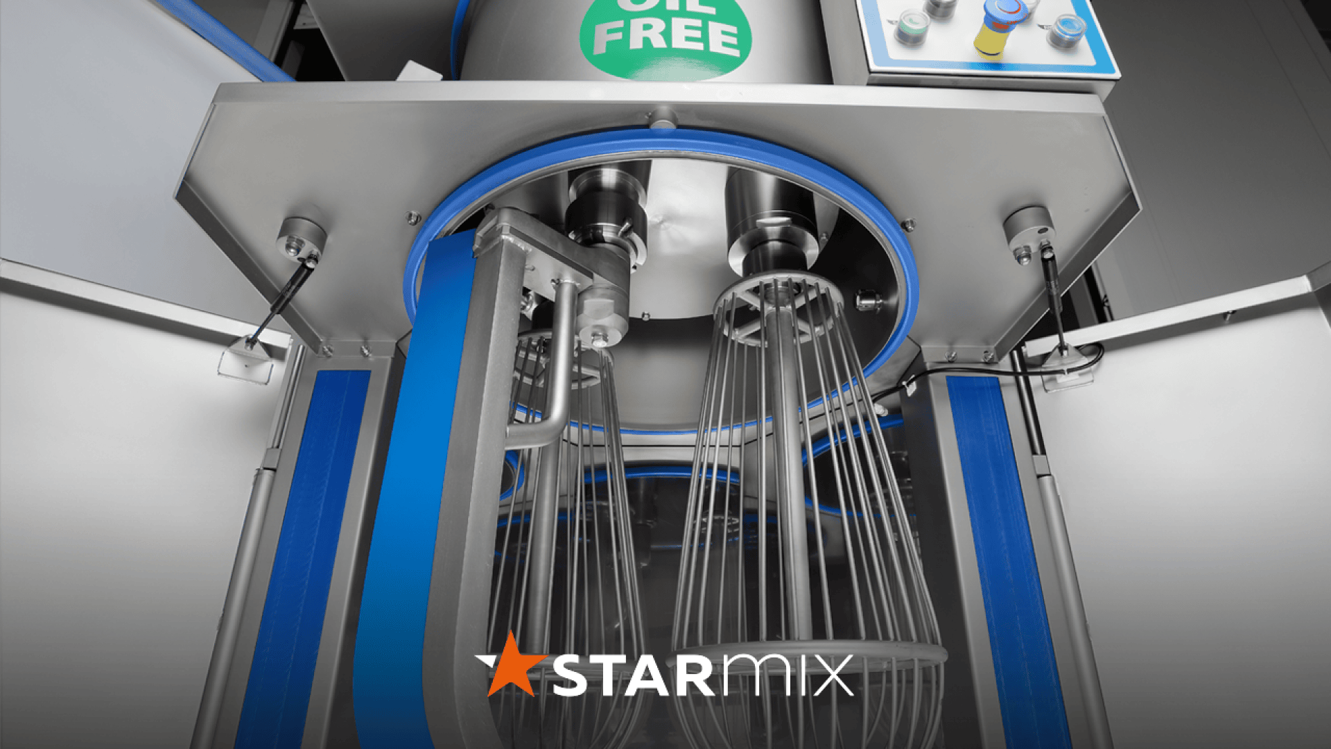 Close-up of an industrial mixing machine with several wire whisks, labeled OIL FREE at the top. At the bottom is the brand name STARMIX with a star symbol.