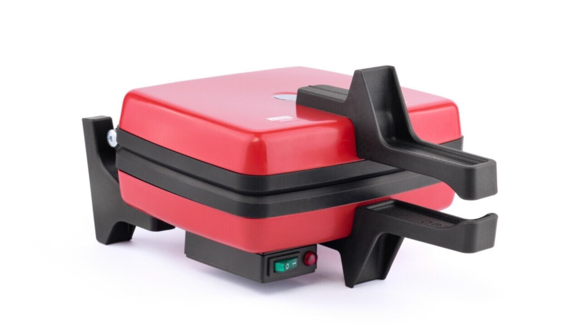 A red and black waffle maker with a closed lid, featuring large black heat-resistant handles and a green power switch on the base, shown on a white background.