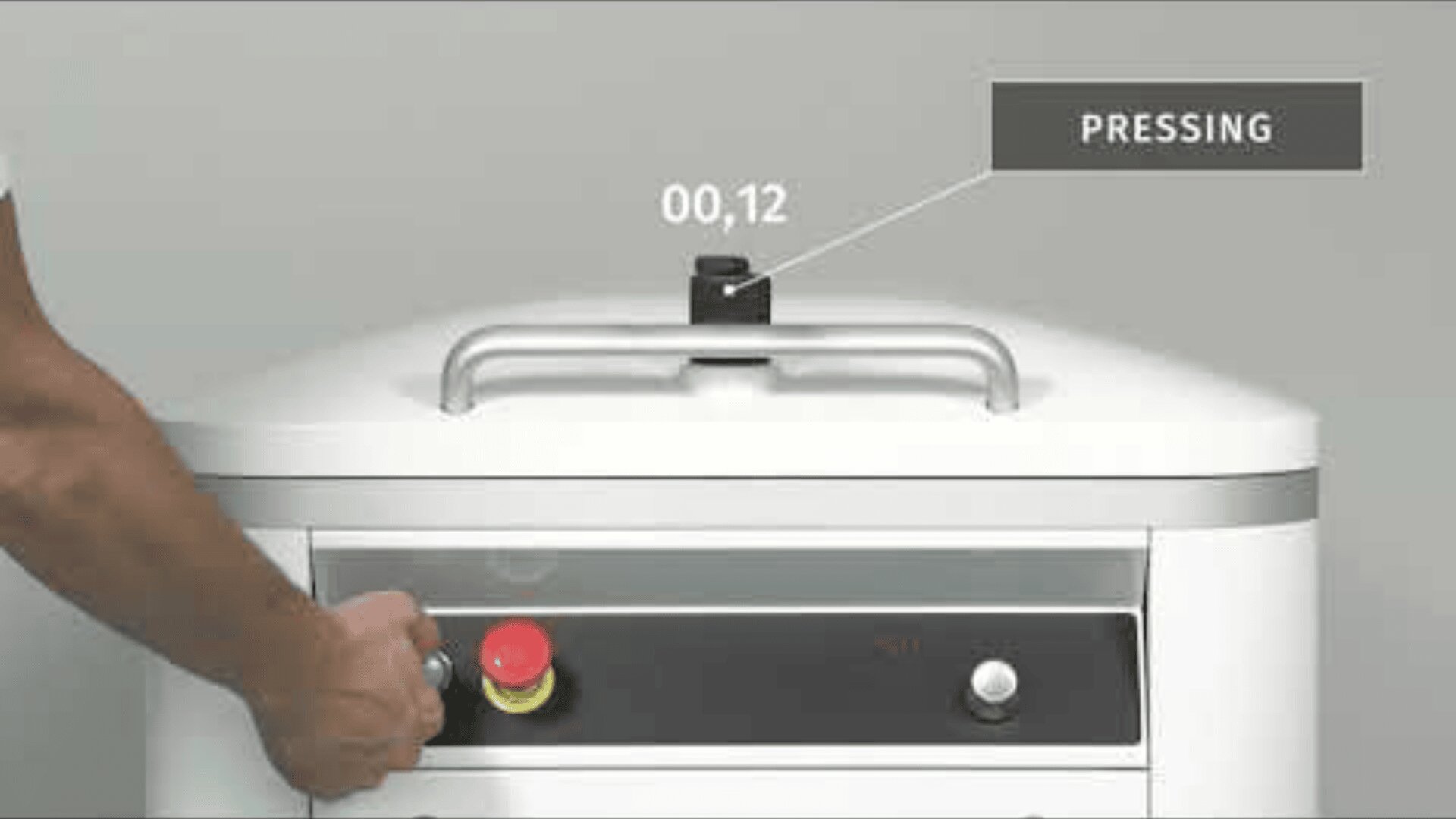 A person presses a red emergency stop button on a white industrial machine. A timer above the machine displays 00.12 and a label reads PRESSING against a plain background.