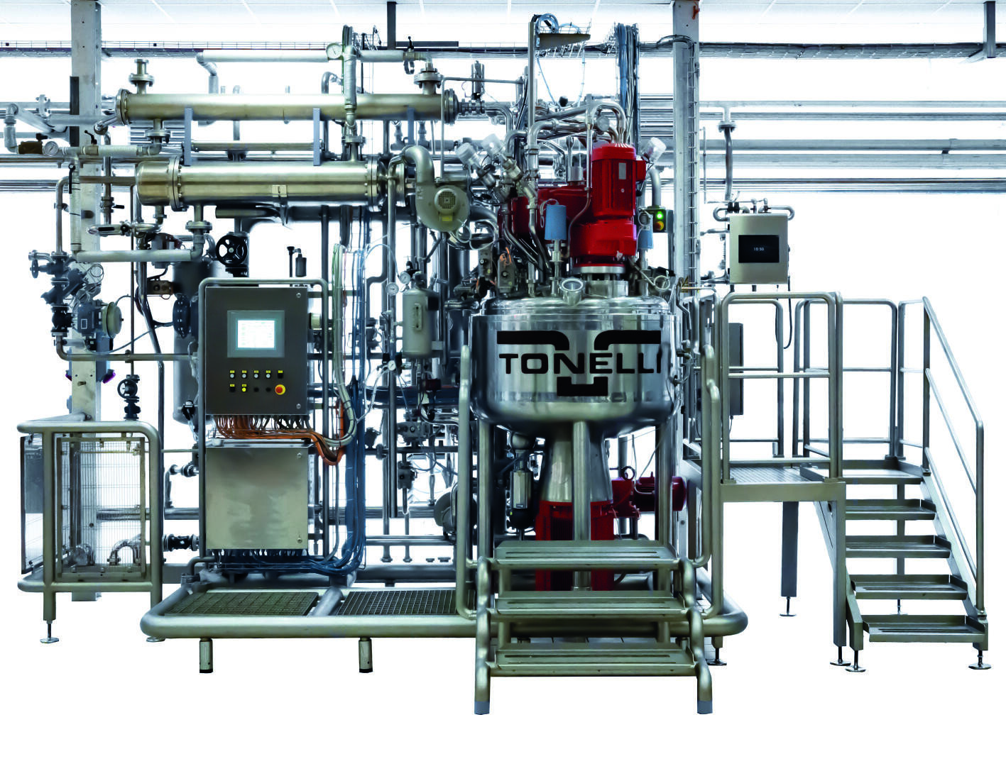 Industrial mixing machine with several metal pipes, control panel and a large mixing bowl with the inscription TONELLI. On the right side there is a staircase and a railing for operator access, against a bright, clean background.