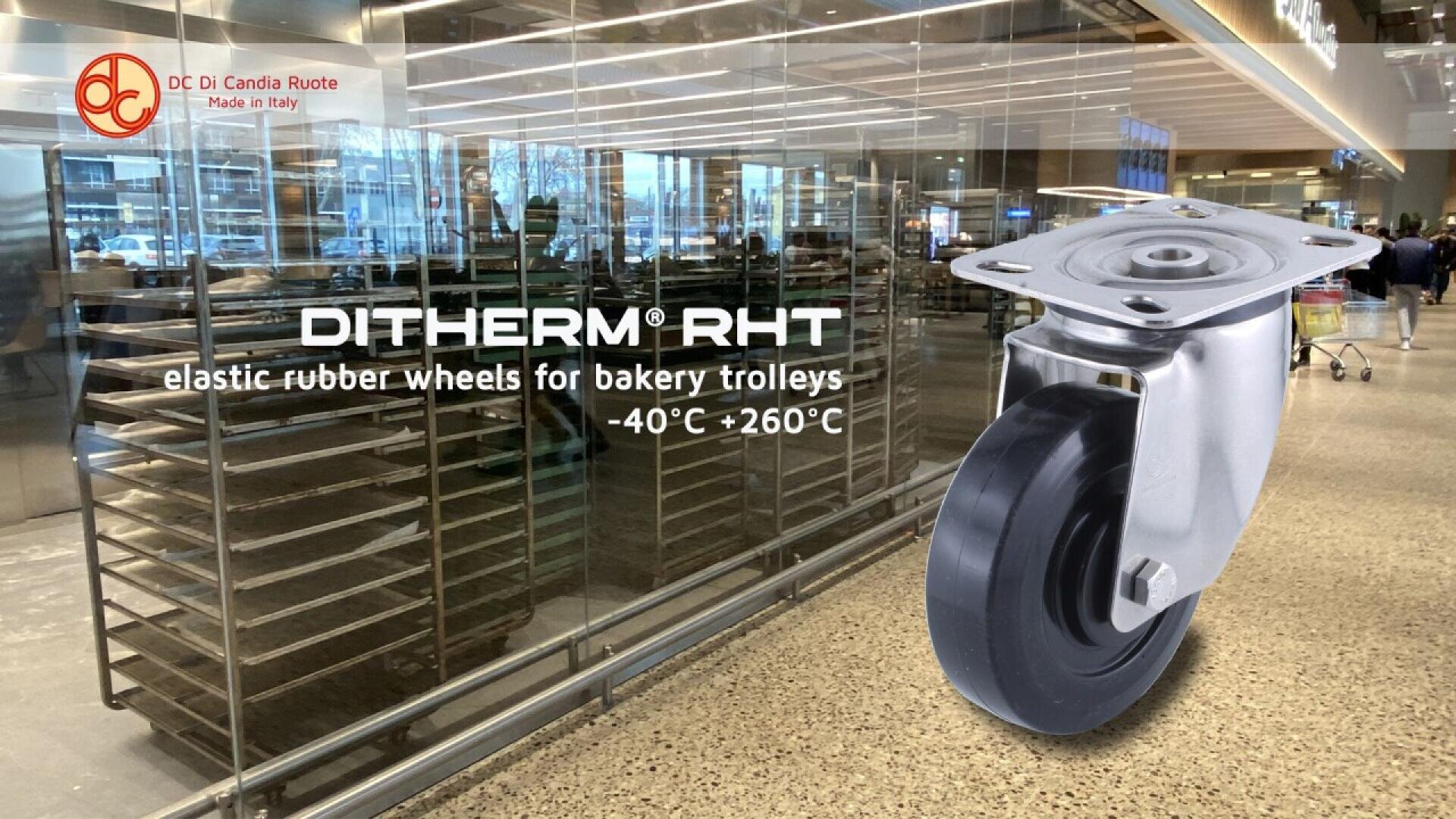 In einer modernen Bäckerei ist eine große Rolle vor Backstühlen und Öfen ausgestellt. Der Text lautet: DITHERM RHT elastische Gummiräder für Bäckereiwagen -40°C +260°C. Oben links erscheint das Logo von DC di Candia Ruote.