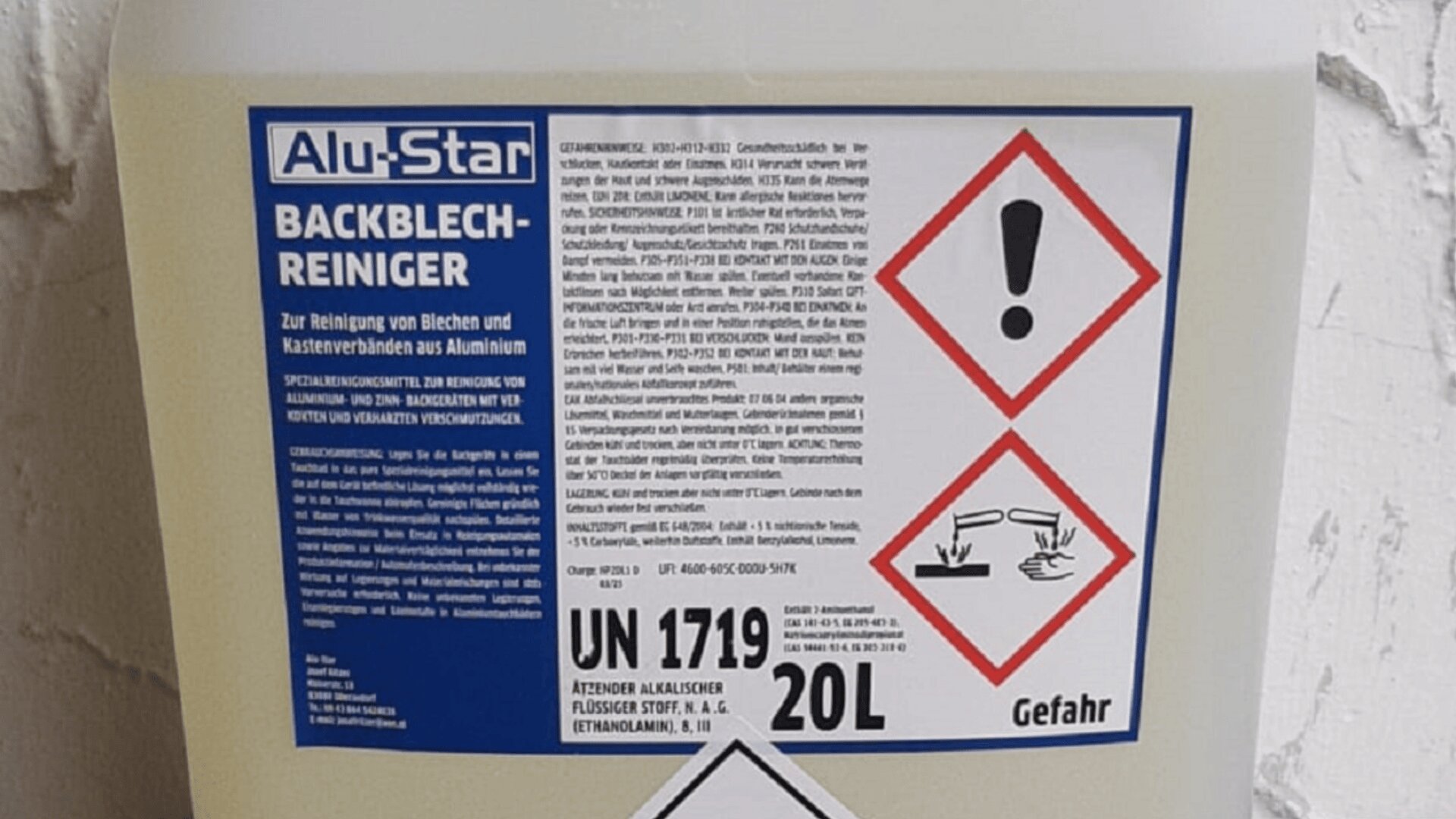 Ein 20-Liter-Behälter mit der Aufschrift „Alu-Star Backblechreiniger“ mit Warnsymbolen für ätzende Gefahren und einer ausführlichen Gebrauchsanweisung in deutscher Sprache, fotografiert vor einer hellen Wand.