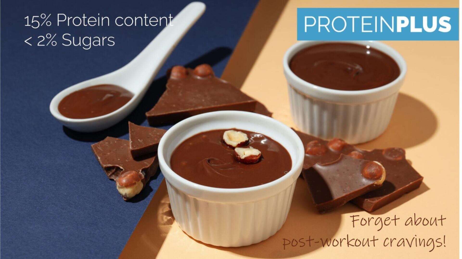 Zwei weiße Förmchen und ein Löffel mit Schokoladendessert sind von Schokoladenstücken mit Nüssen umgeben. Der Text hebt hervor: „15 % Proteingehalt, < 2 % Zucker“, „PROTEINPLUS“ und „Vergessen Sie Heißhungerattacken nach dem Training!“.