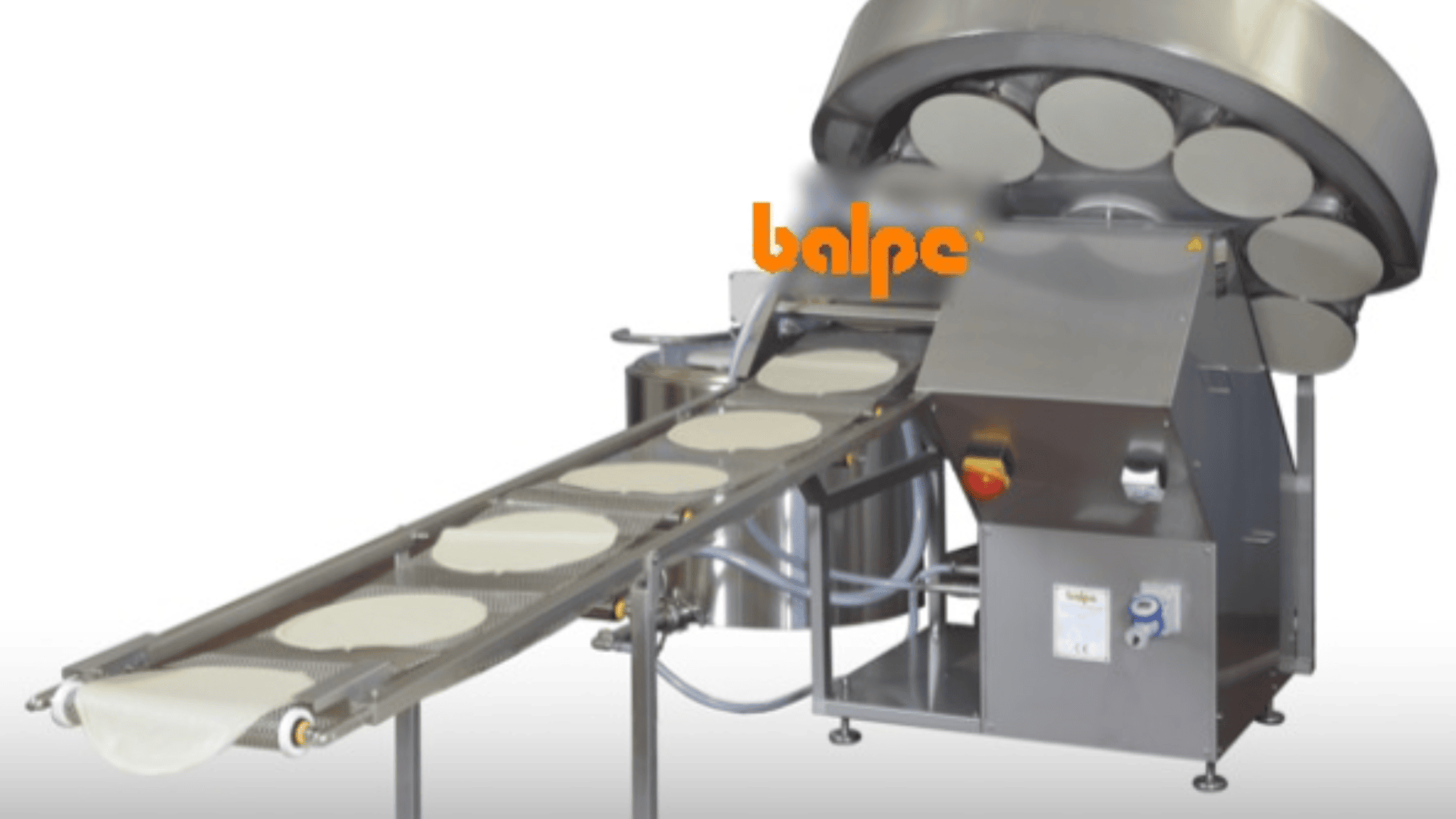 A stainless steel industrial tortilla-making machine automatically presses and conveys flat tortillas along a conveyor belt. The brand name balpe is visible on the machine in orange letters.