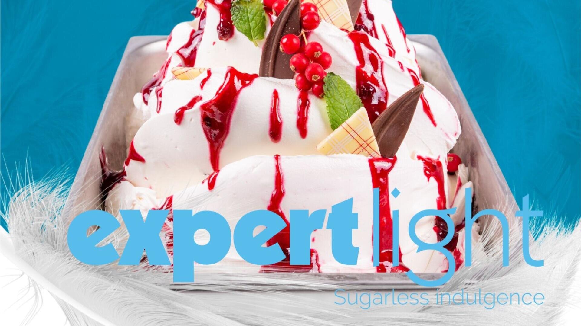 Ein Tablett mit Schlagsahne oder Eisdessert, garniert mit roter Beerensauce, Schokoladenstückchen, roten Johannisbeeren und Minzblättern. Die Worte „Expert Light“ und „Zuckerfreier Genuss“ erscheinen über dem Bild.