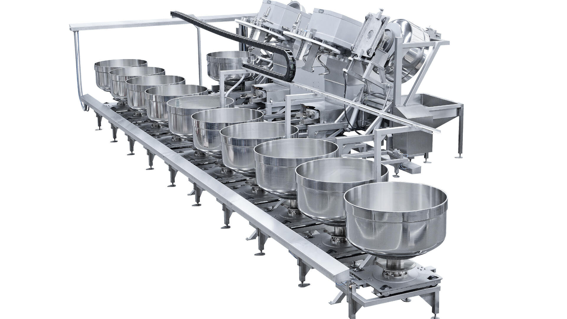 A stainless steel industrial machine with multiple large mixing bowls arranged in a row, connected to automated equipment, likely used in food production or processing.