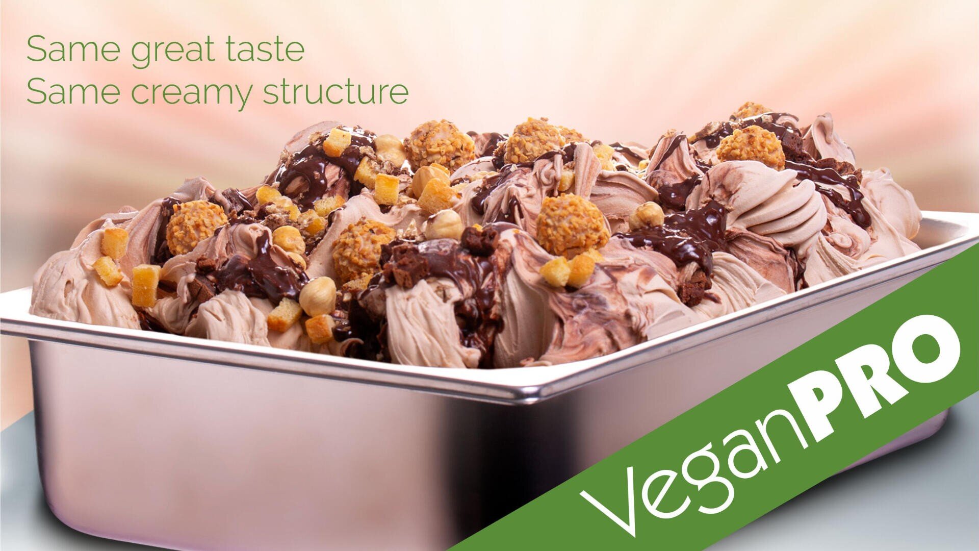 A metal tray filled with creamy, chocolate-swirled vegan ice cream topped with various crunchy pieces. Green text reads, “Same great taste, Same creamy structure,” and “Vegan PRO” is written across a green banner.