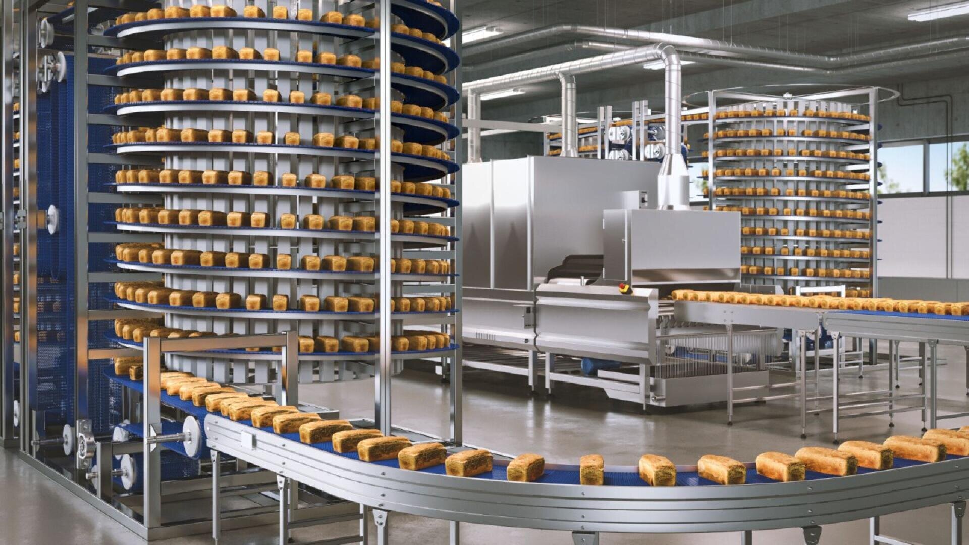 Industrial bakery with rows of loaves of bread on spiral and straight conveyor belts, moving through automated machinery inside a modern factory with stainless steel equipment.