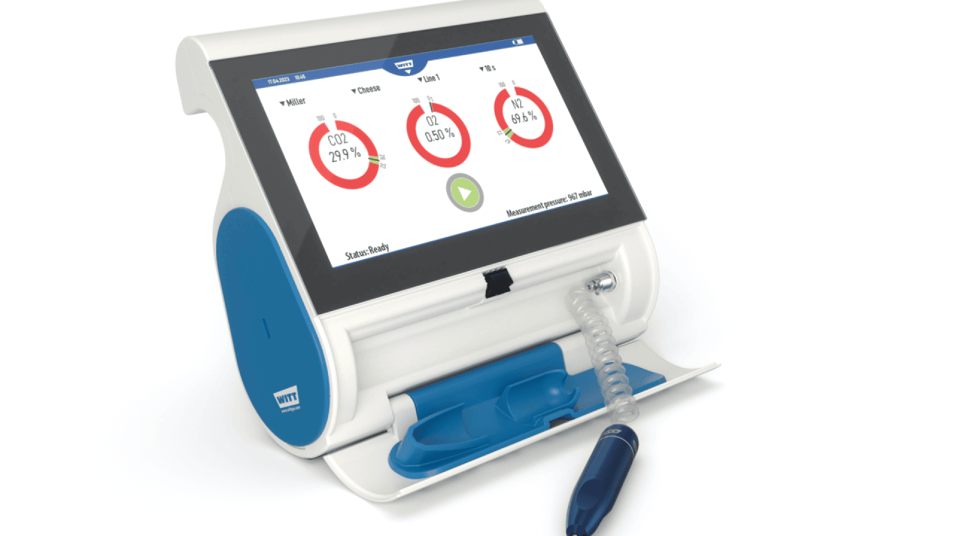 A medical device with a digital touchscreen displaying circular charts, buttons, and readouts, featuring a coiled tube and handheld probe resting in a blue holder at the base.