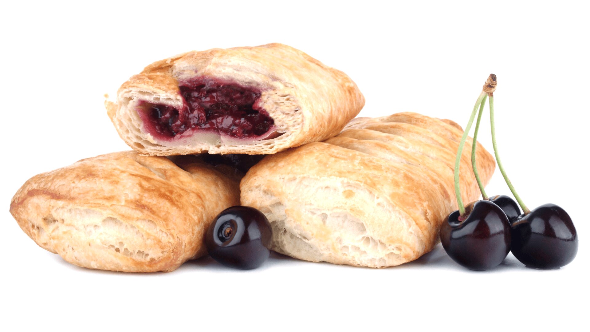 Three golden, flaky pastries are shown with one cut open to reveal a cherry filling. Two fresh cherries with stems and one without are placed beside the pastries on a white background.