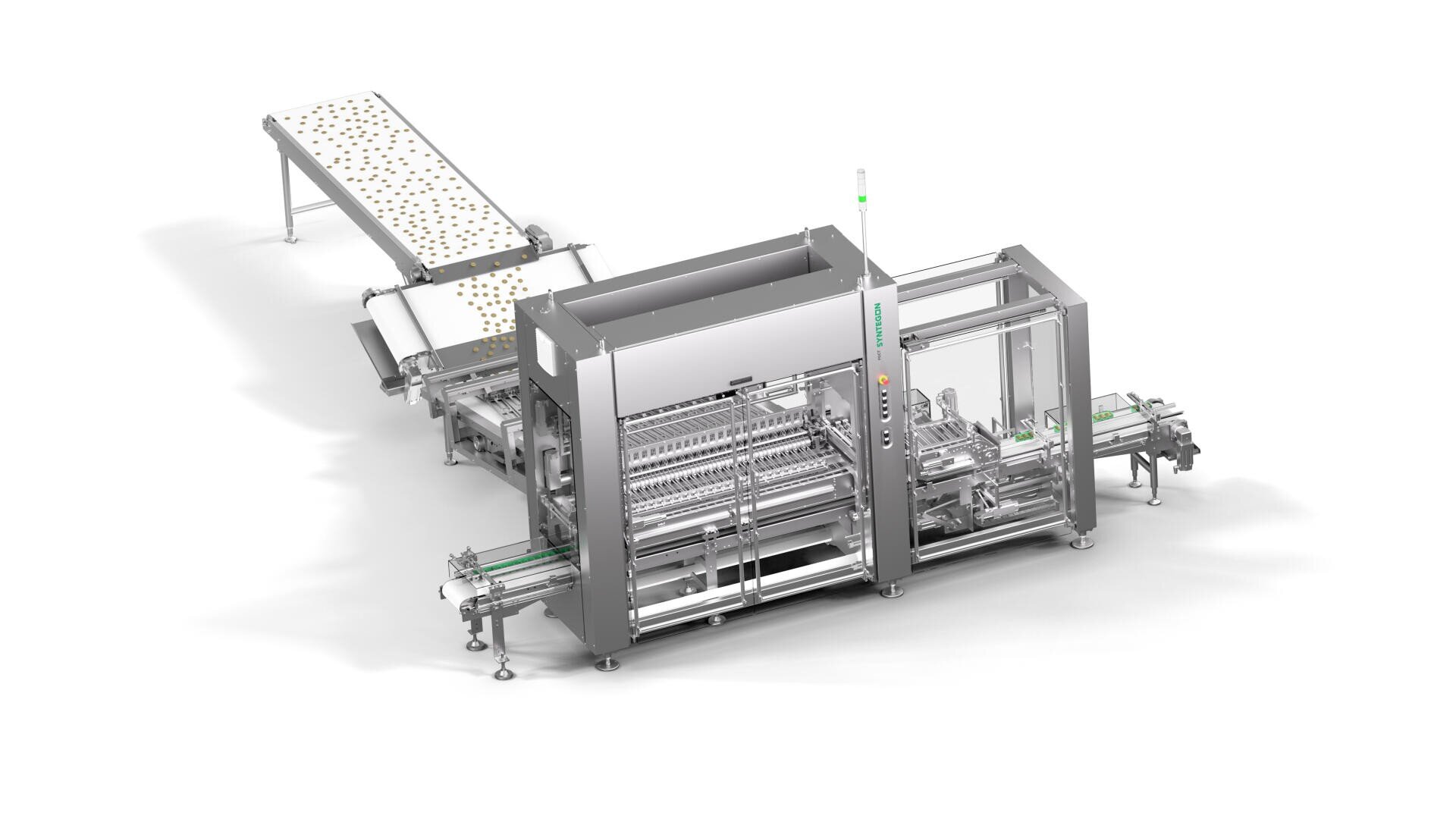 A stainless steel industrial food processing machine with conveyor belts, designed for automated production, stands on a white background. The machine processes items in trays moving along the conveyors.
