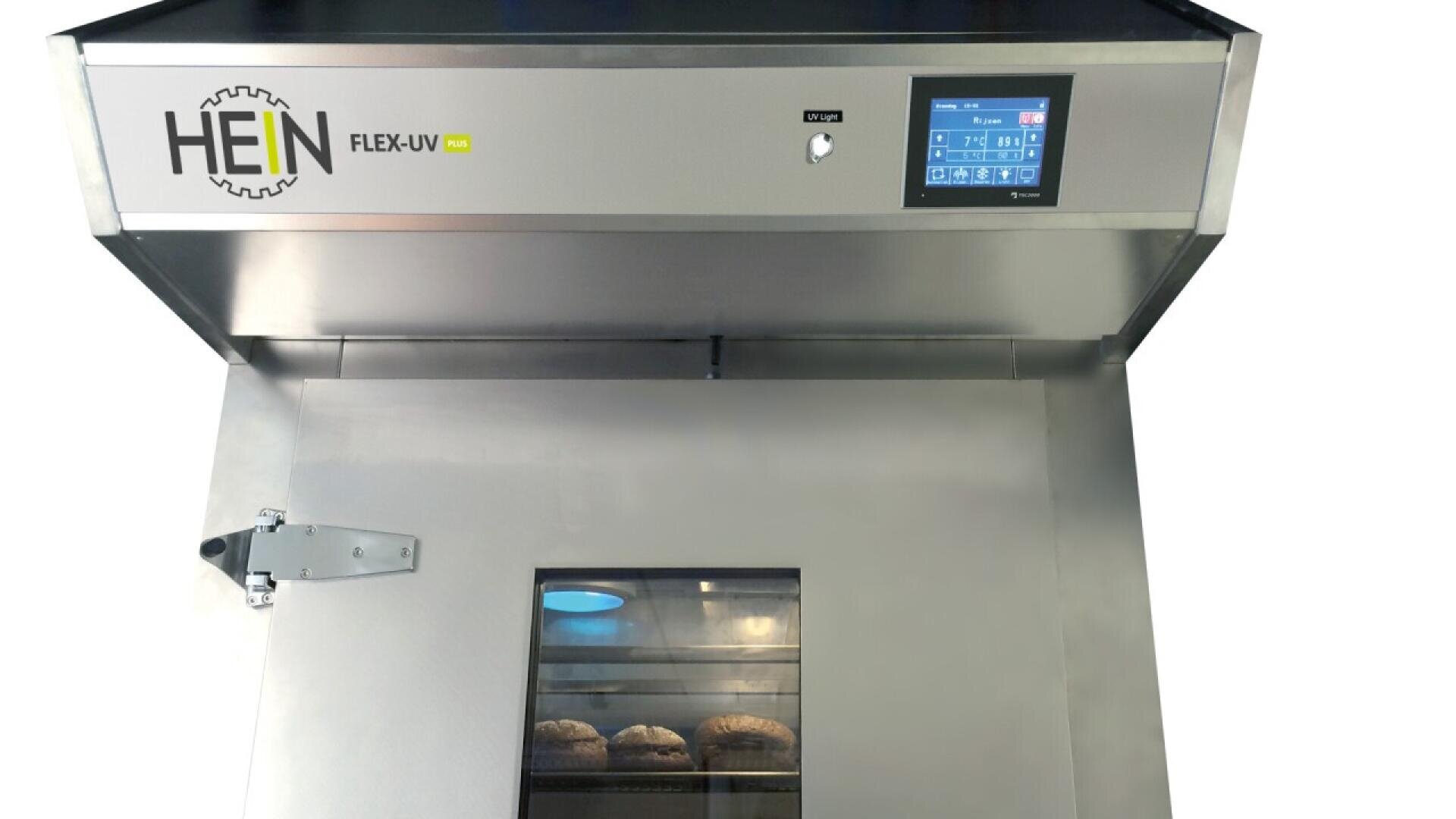 A stainless steel industrial oven labeled HEIN FLEX-UV with a digital control panel and a window showing several loaves of bread baking inside.