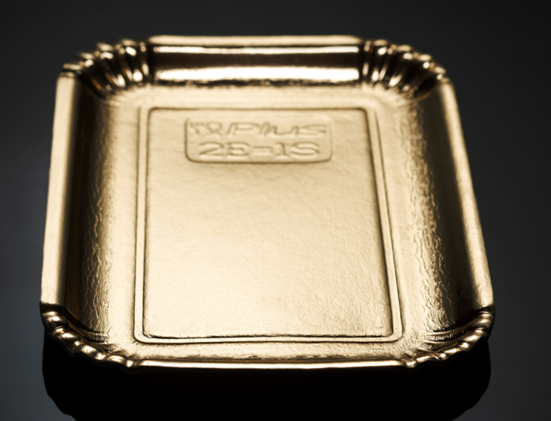 A small rectangular gold-colored tray with decorative edges and embossed text on its surface, placed on a reflective black background.